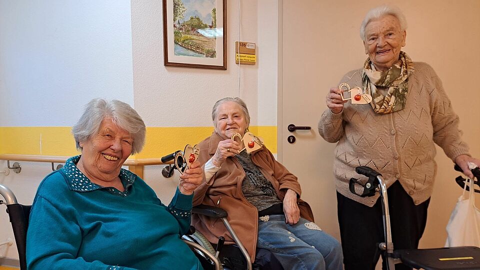 Drei Senioren freuen sich über Geschenk zum Valentinstag