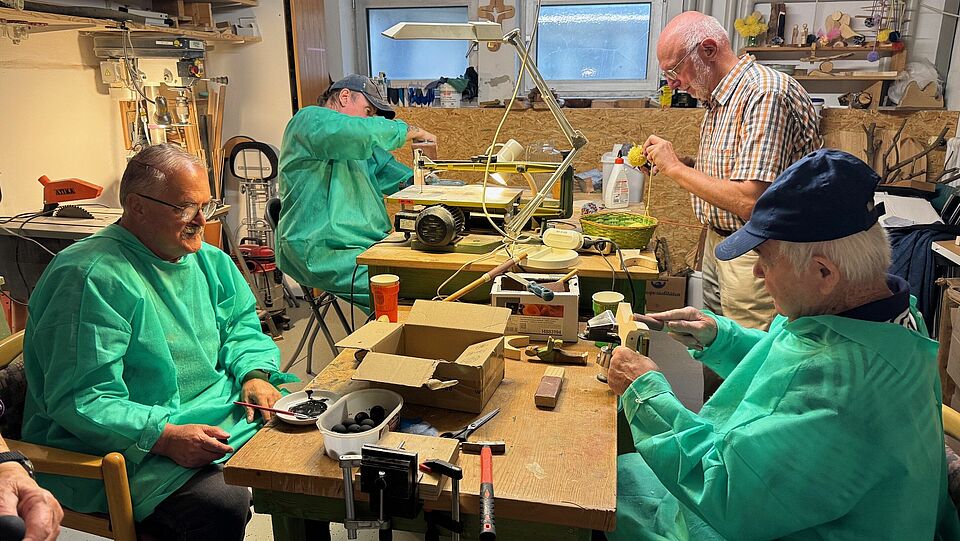 Senioren basteln mit Holz in einer Werkstatt