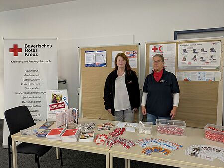 Zwei Mitarbeiterinnen stehen am Infostand des BRK Amberg-Sulzbach