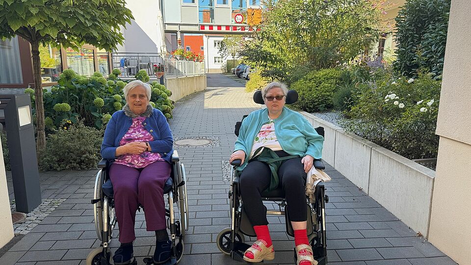 Zwei Seniorinnen im Rollstuhl auf einem Ausflug
