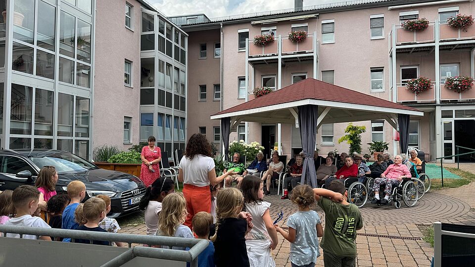 Veranstaltung mit Kindern und Senioren unter einem Gartenpavillon